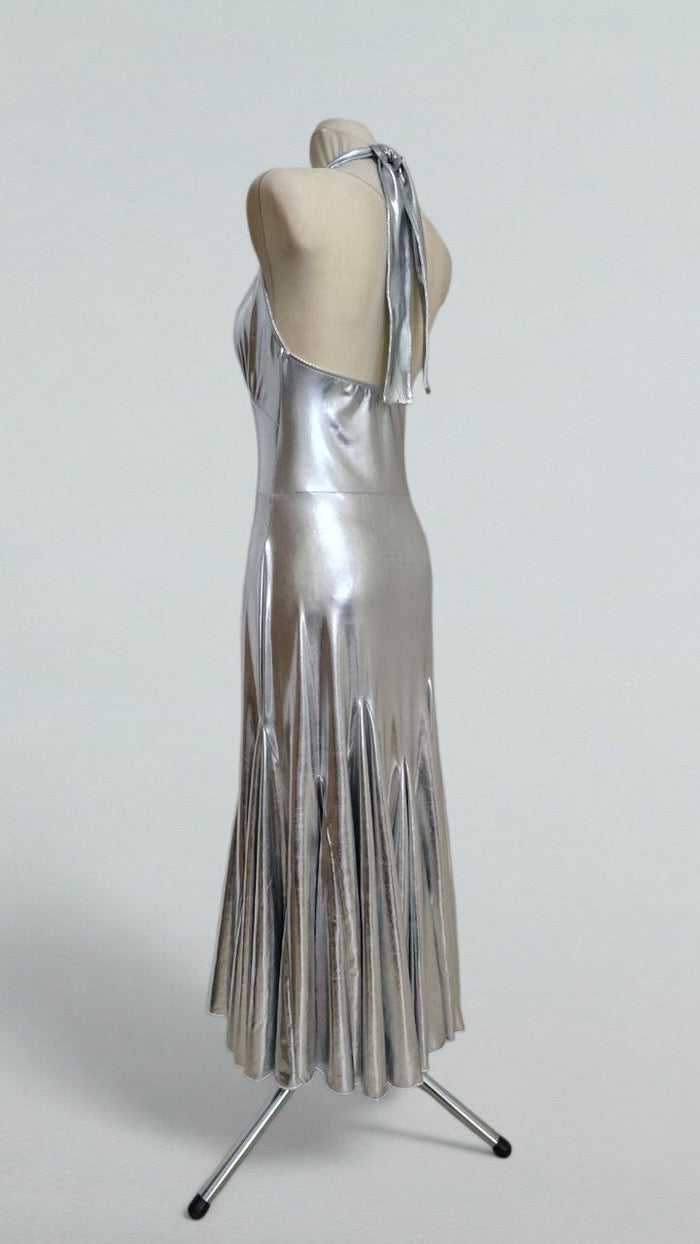 metallic silver halter dress Silver shimmer, open-back drama, and the perfect halter silhouette for your next evening out. A statement maxi dress made for cocktail nights, vacation dinners, rooftop events, and formal summer occasions. Available at